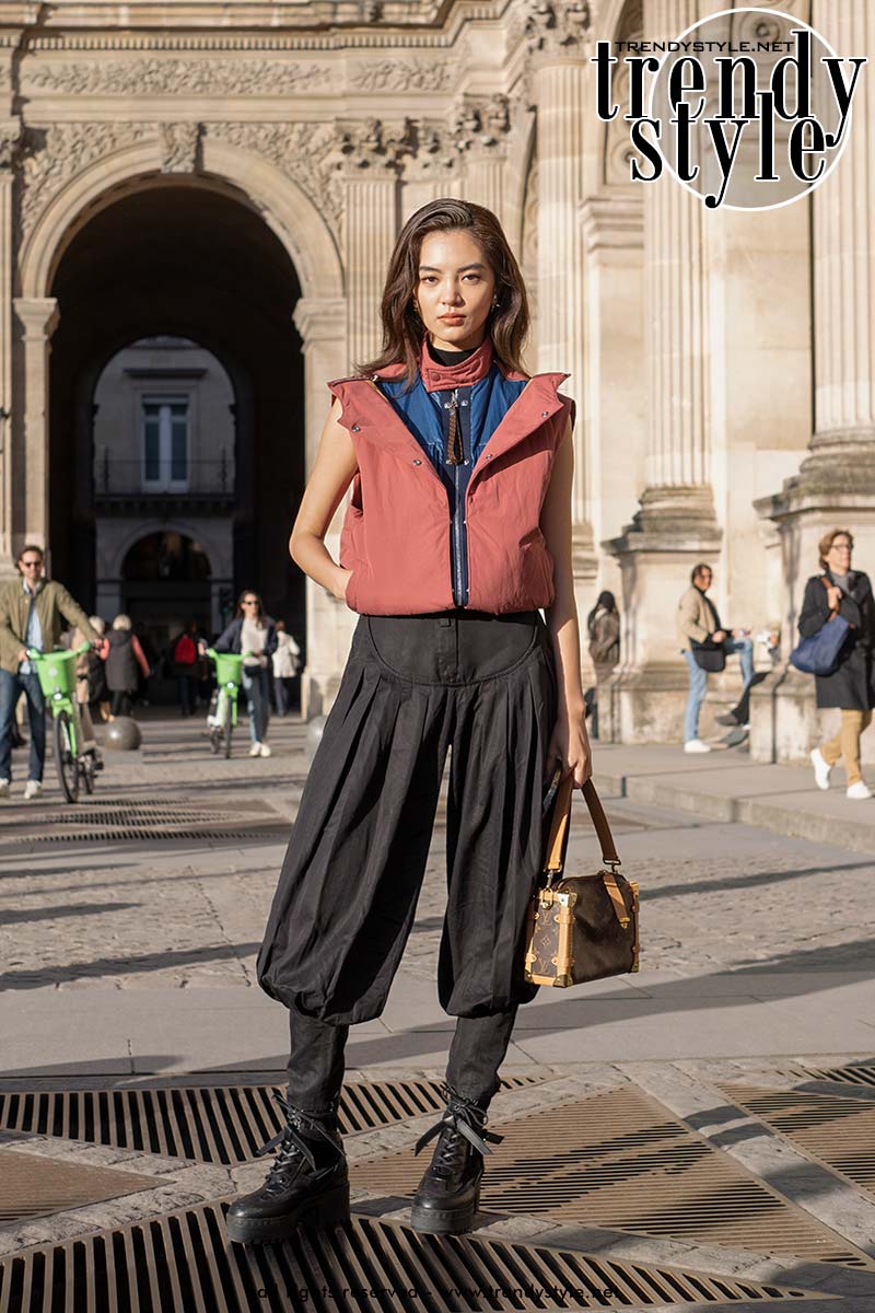 Streetstyle. Fan Lingxi in een Louis Vuitton gilet met LV bag. Foto ADVERSUS